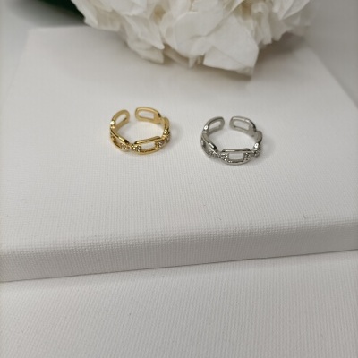 Dois anéis dourado e prateado com detalhes brilhantes sobre tecido branco