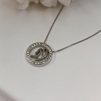 Colar prateado com pendente redondo decorado com pedras brilhantes e motivo floral.