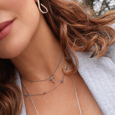 Colares prateados com pingentes delicados e brincos dourados torcidos