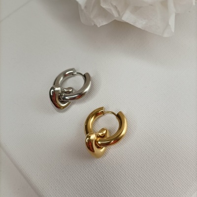 Par de brincos em metal prata e dourado com design de argola e nó