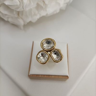 Anel com três pedras transparentes facetadas emolduradas a dourado