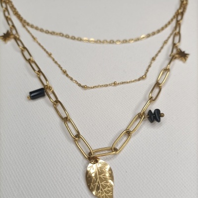 Colar dourado com pingentes diversos incluindo folha e contas pretas