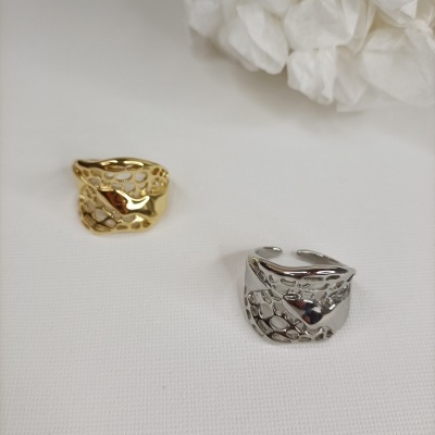 Anéis dourado e prateado com padrão perfurado sobre fundo branco