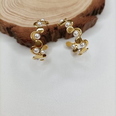 Brincos dourados com pérolas e fundo branco com madeira