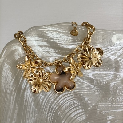 Pulseira dourada com pendentes de flores em vidro texturizado