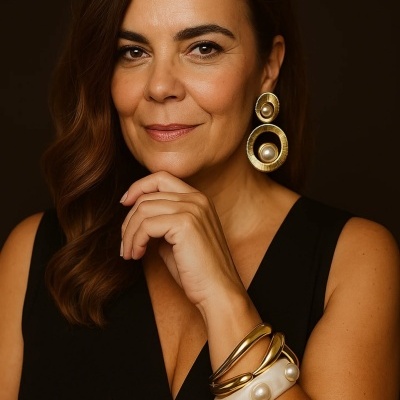 Mulher com brincos dourados grandes com pérolas e pulseiras douradas e brancas com pérolas