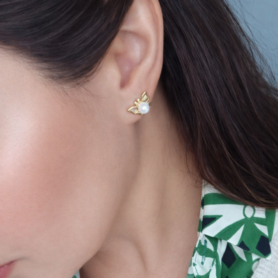 Brinco abelha dourado com pérola branca na orelha de mulher