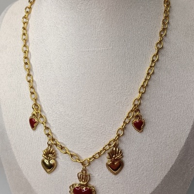 Colar dourado com cinco pendentes em forma de coração com detalhes vermelhos e dourados