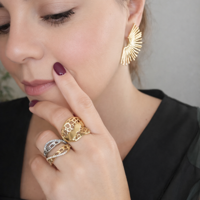 Mulher com jóias douradas e prateadas e vestido preto