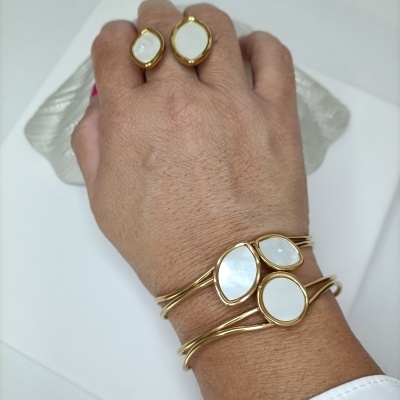 Mão com anéis e pulseira dourados com pedras brancas