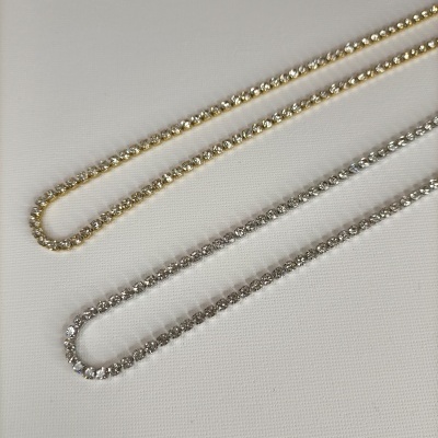 Duas pulseiras brilhantes dourada e prateada em fundo branco