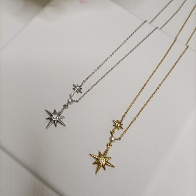 Colares com pendentes em forma de estrelas cinzenta e dourada com pedras brilhantes
