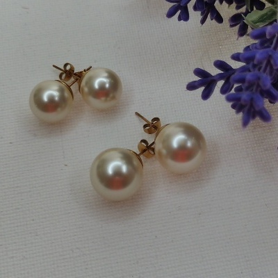 Dois pares de brincos de pérola com fecho de ouro e flores roxas em fundo branco.