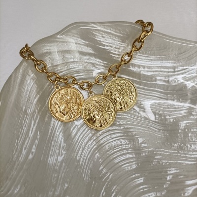 Brincos dourados com corrente e medalhas redondas em prato texturizado