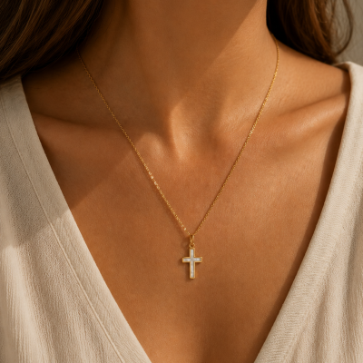 Colar dourado com pendente cruz branca ao pescoço