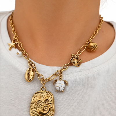 Colar dourado com pendentes marinhos usados sobre t-shirt branca