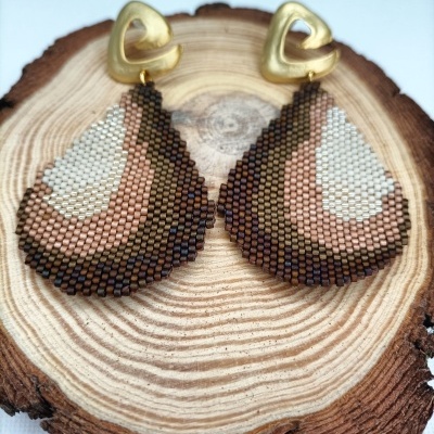 Brincos com base de metal dourado e pendente de contas coloridas em padrão geométrico sobre base de madeira redonda