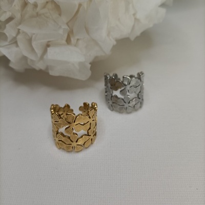Anéis metálicos dourado e prateado de design floral sobre tecido branco