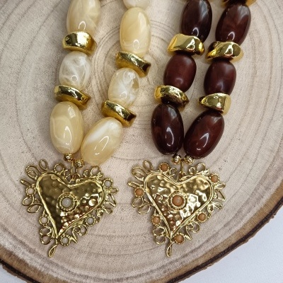 Dois colares com contas grandes creme e castanho com pendentes de coração dourados