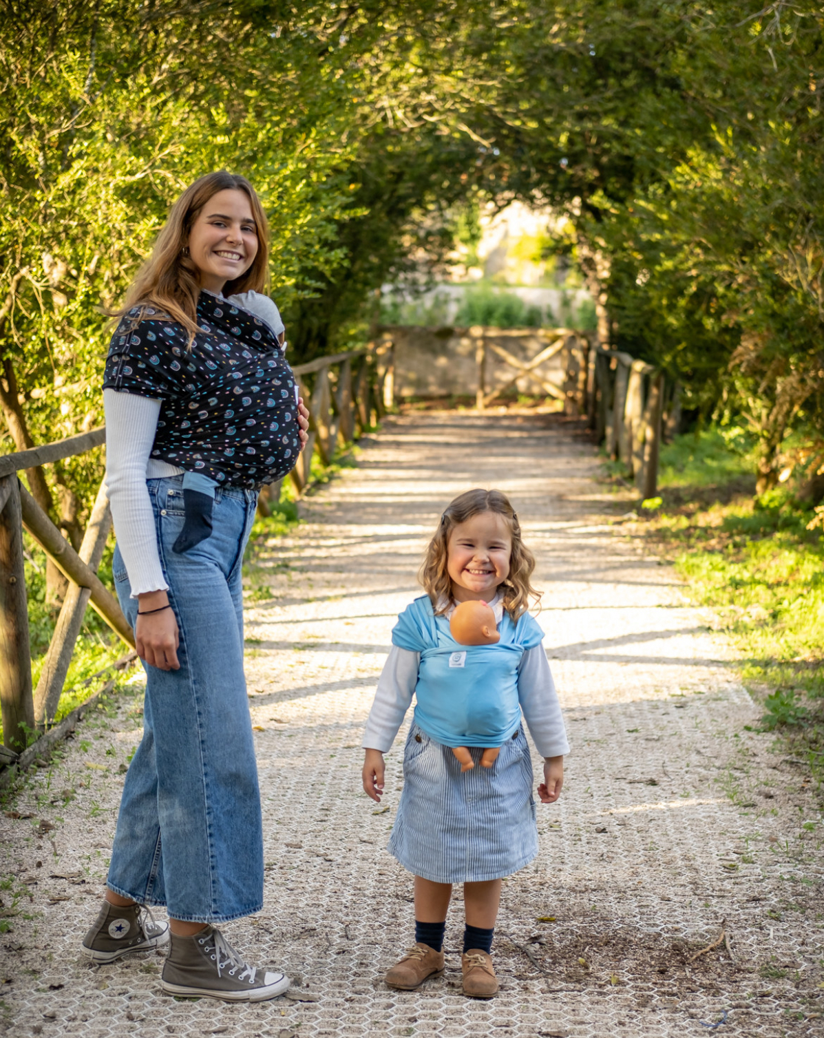 ISling4kid - Porta-bonecas Mulher e criança a usar cangurus de bebé em caminho ao ar livre