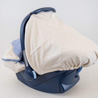 Cesto de transporte para bebé azul com cobertura bege em fundo branco