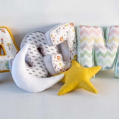 Almofadas em forma de letras A, C e M e uma almofada amarela em forma de estrela