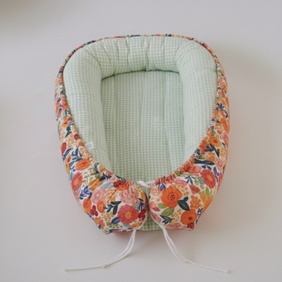 Ninho de bebé com interior xadrez verde claro e exterior floral colorido