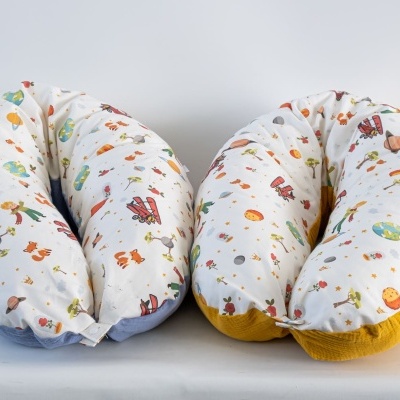 Dois almofadões brancos com estampas coloridas e base azul e amarela