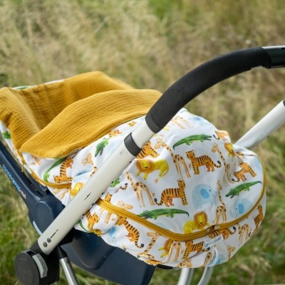 Carrinho de bebé com capa estampada de animais selvagens e manta amarela