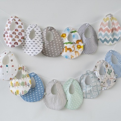 Onze babetes coloridos com vários padrões pendurados contra parede branca