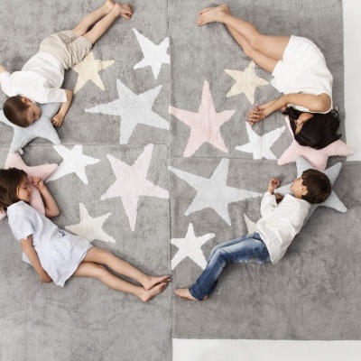 Tapete cinzento com estrelas coloridas e crianças deitadas