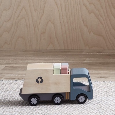 Carrinha de madeira azul e bege com símbolo de reciclagem e caixas coloridas sobre tapete