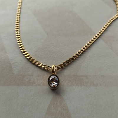 Colar dourado com pendente oval e pedra transparente