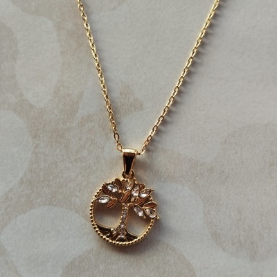 Colar dourado com pendente em forma de árvore com pedras brilhantes