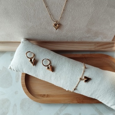 Conjunto de joalharia dourada com coração em colar, brincos e pulseira