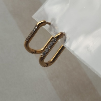 Brincos dourados em forma de U com pedras translúcidas