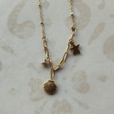 Colar dourado com pendentes de concha, estrela e pedra transparentes