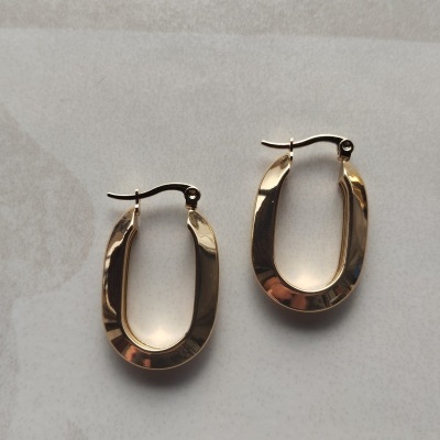 Brincos de argola oval dourados com fecho articulado sobre fundo claro