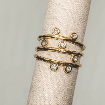 Anel dourado espiral com cristais em suporte de tecido