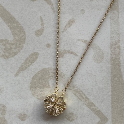 Colar dourado com pendente de trevo de quatro folhas e pedras brilhantes