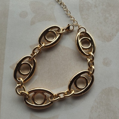 Pulseira dourada com elos ovais e círculo central