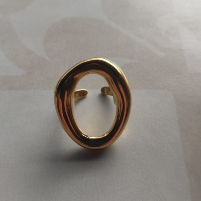 Anel dourado oval assimétrico com superfície lisa