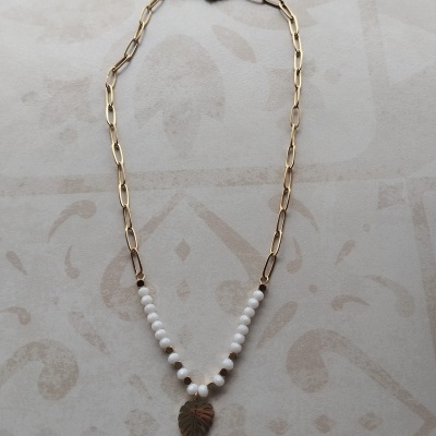Colar dourado com contas brancas e pendente em forma de folha