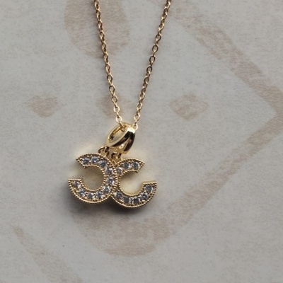 Colar dourado com pendente em formato CC decorado com pedras brilhantes