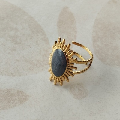 Anel dourado com pedra cinza e decoração em forma de sol