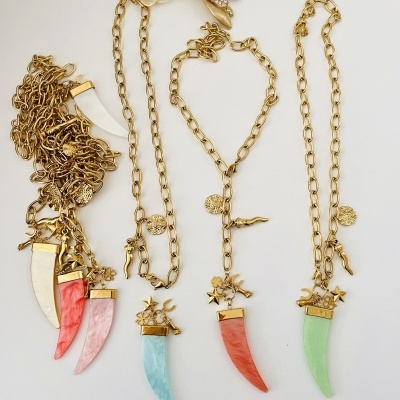 Colar dourado com pendente em forma de dente colorido