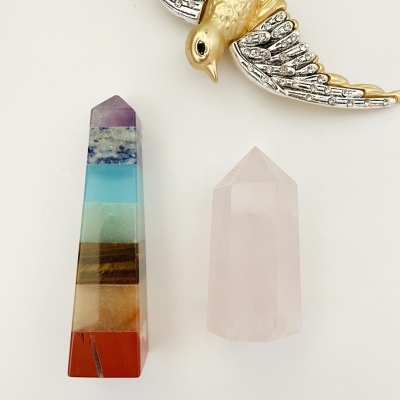 Duas pedras polidas em formato de pirâmide coloridas e uma figura decorativa de pássaro