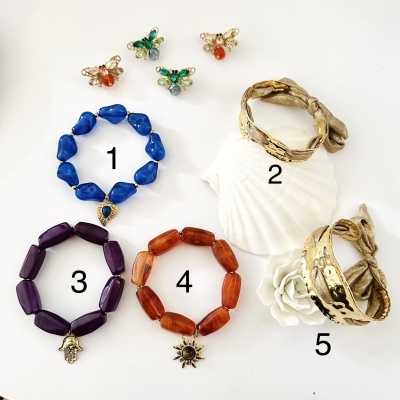 Pulseiras coloridas numeradas e brincos de borboleta organizados sobre fundo branco