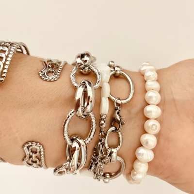 Pulseiras femininas prateadas e pulseira de pérolas no pulso