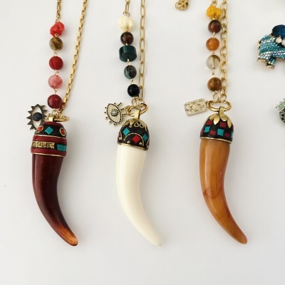Três colares com pendentes de corno decorados em várias cores e contas variadas